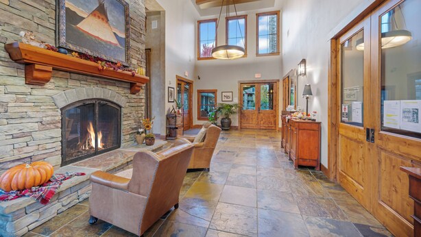 A spacious lobby with a stone fireplace, leather sofas, and wooden accents.