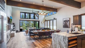 Una cocina moderna con una isla grande, armarios de madera oscura y vistas al exterior.