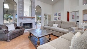 A spacious living room with a fireplace, leather sofas, and a wooden coffee table. - ScottsdaleStays 10BR-6BA Multimillion Acre Estate-Pool-SportCourts-SPECIAL DEALS (Phoenix)