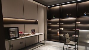A modern kitchen with a marble countertop, a built-in refrigerator, and a seating area with a chair. - Yuezhi Hotel Guangzhou Yuexiu Park (Guangzhou)