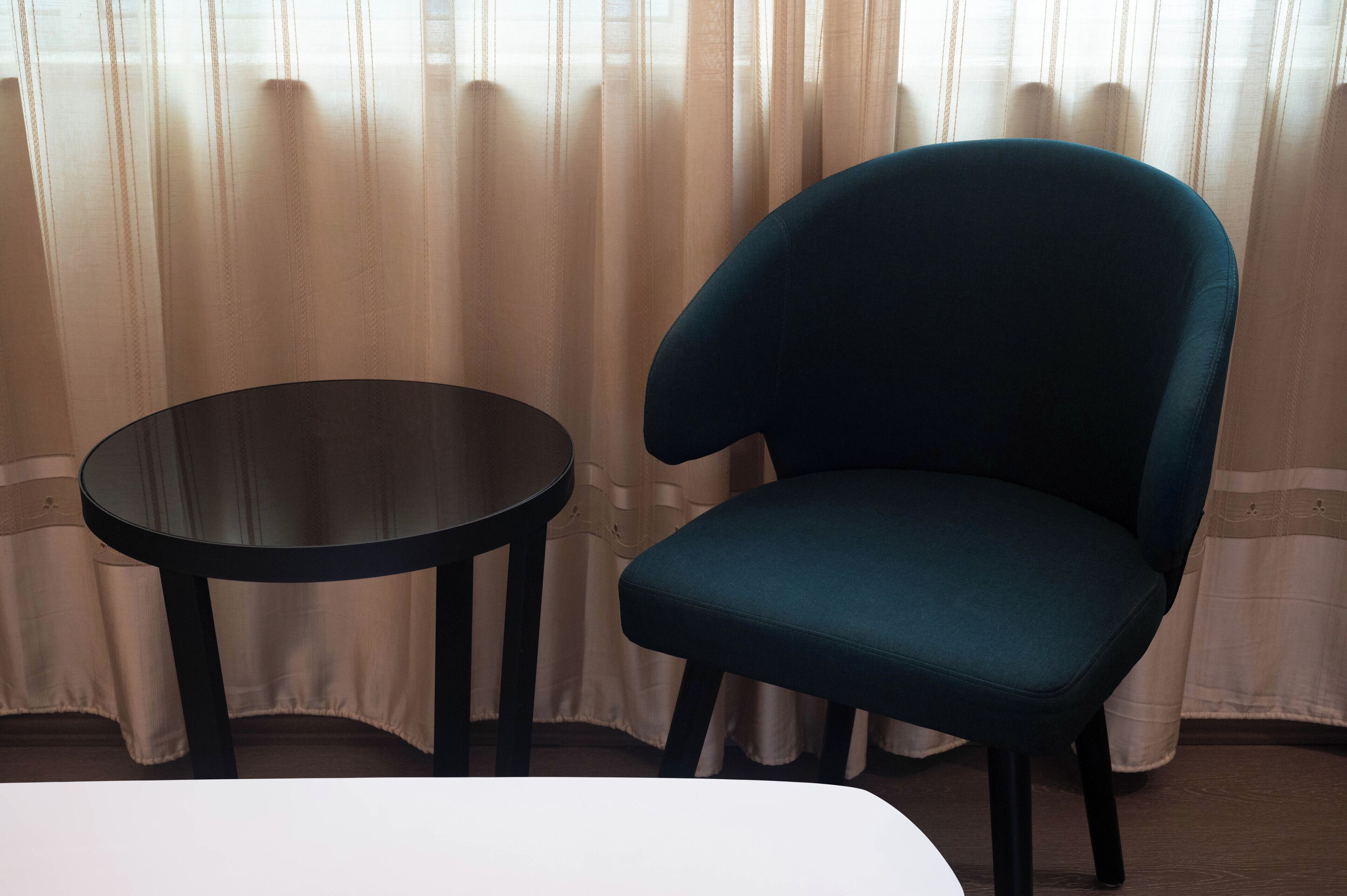 Une pièce avec une seule table ronde et une chaise bleue.