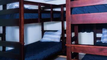 A room with bunk beds, an air conditioning unit, and a tiled floor.