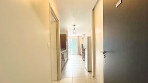 A hallway with a tiled floor, a door with a number plate, and a ceiling light. - Fare Hinaiti - Premium Private Studio with sea vue and terrace (Faaa)