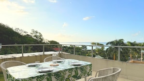 A dining table set on a balcony with a view of the ocean. - Fare Hinaiti - Premium Private Studio with sea vue and terrace (Faaa)