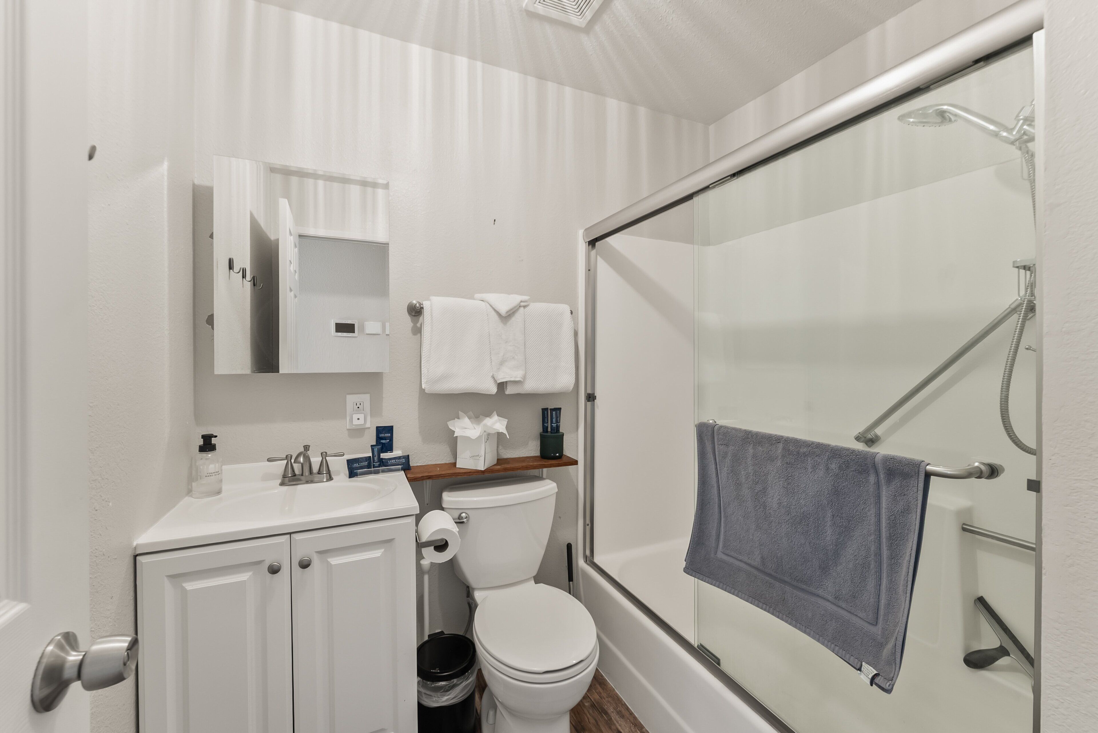 Une salle de bain avec des toilettes, un lavabo et une douche.