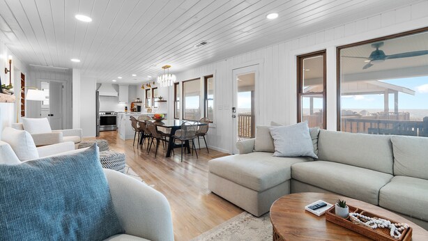 A spacious living area with a large sofa, a coffee table, and a dining table. - "You are My Sunshine" Fully Renovated, 3 Bedroom, 2 Bathroom, Oceanfront Home (Holden Beach)