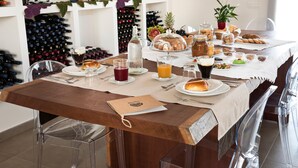 A dining table set with various food items, wine bottles, and glasses. - Room 'Riofavara Winery - Suite Barrique' with Private Terrace, Wi-Fi and Air Conditioning (Ispica)
