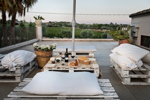 A rooftop terrace with a table set for dining, a potted plant, and a view of the countryside. - Room 'Riofavara Winery - Suite Vigna' with Private Terrace, Wi-Fi and Air Conditioning (Ispica)