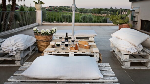 A rooftop terrace with a table set for dining, a potted plant, and a view of the countryside. - Room 'Riofavara Winery - Suite' with Private Terrace, Wi-Fi and Air Conditioning (Ispica)