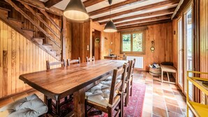Ein Essbereich aus Holz mit einem großen Tisch, Bänken und einer Treppe.