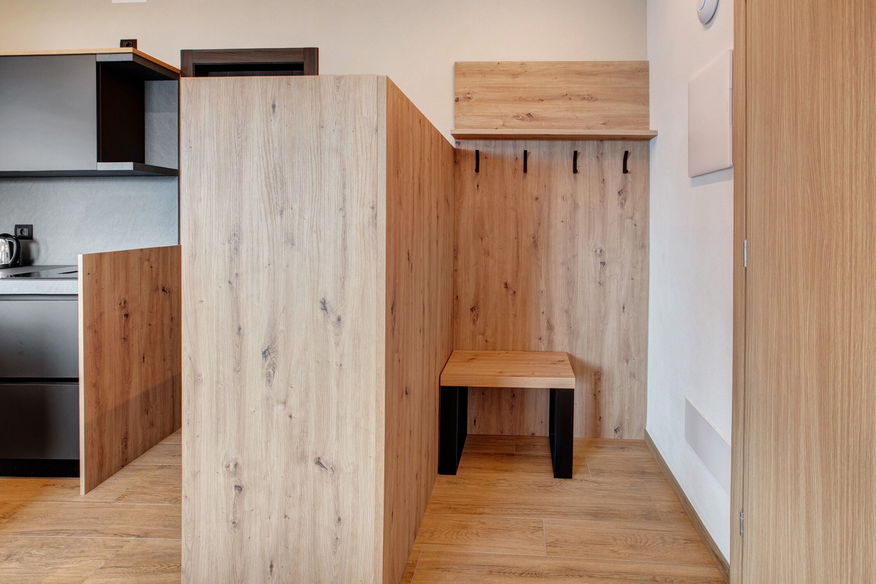 A modern kitchen with wooden cabinetry and a built-in bench.