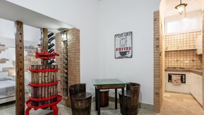Cocina compacta con una mesa de vidrio, sillas de madera y un botellero para vino tinto.