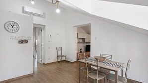 Um interior moderno com área de jantar, um relógio e um aparelho de ar condicionado.