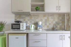A kitchen with a microwave, kettle, coffee maker, and a sink. - Apartment 'No 10' with Shared Pool, Wi-Fi and Air Conditioning (Kalymnos)