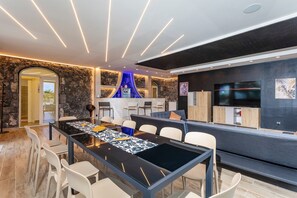 Una cocina moderna con una isla grande, electrodomésticos integrados y un televisor de pantalla plana.