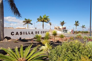 Segnaletica per 'CASILLA DE COSTA', con palme e piante desertiche sullo sfondo.