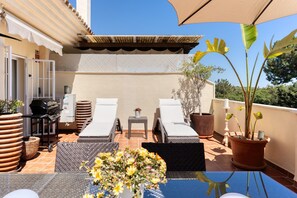 A rooftop terrace with two lounge chairs, a small table, a grill, and potted plants. - Apartment 'Lechuza Elviria Marbella 2' with Shared Pool, Wi-Fi and Air Conditioning (Marbella)
