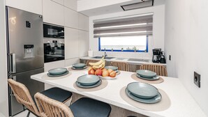 A modern kitchen with a stainless steel refrigerator, double oven, and a large window with a view. - Country House 'Navarino Baths' with Sea View, Wi-Fi and Air Conditioning (Vromonérion)
