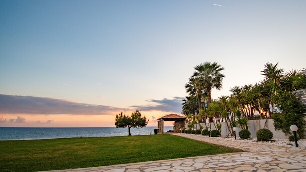 A paved pathway leading to a gazebo with a view of the sea and palm trees. - Country House 'Navarino Baths' with Sea View, Wi-Fi and Air Conditioning (Vromonérion)