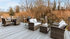 A deck with wicker furniture, a grill, and a glass table. - 2 bedroom accommodation in Bridgnorth (Bridgnorth)