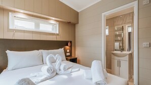 A hotel room with a bed, a nightstand, a mirror, and a bathroom visible through an open door. - 2 bedroom accommodation in Bridgnorth (Bridgnorth)