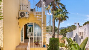 A yellow building with a balcony, a staircase, and a view of the surrounding area. - Apartment 'La Finca' with Sea View, Wi-Fi and Air Conditioning (Teulada)