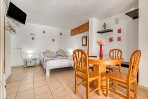 A bedroom with a bed, bedside table, and a TV mounted on the wall. - Apartment 'La Finca' with Sea View, Wi-Fi and Air Conditioning (Teulada)