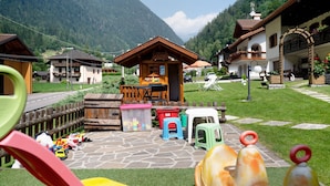 Ein Spielplatz mit Rutsche, Spielgeräten und einem kleinen Gebäude mit einem Schild.