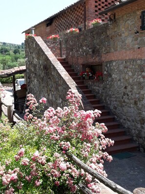 Ein Steinhaus mit einer Treppe, die zu einem Fenster mit Blumen führt.