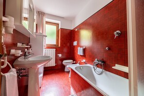 Une salle de bain avec un lavabo, des toilettes et une baignoire.