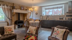 Una sala de estar acogedora con chimenea, comedor y cocina.