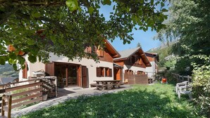 Eine Chalet mit einer Terrassenfläche, Holzmöbeln und Blick auf die umliegende Landschaft.