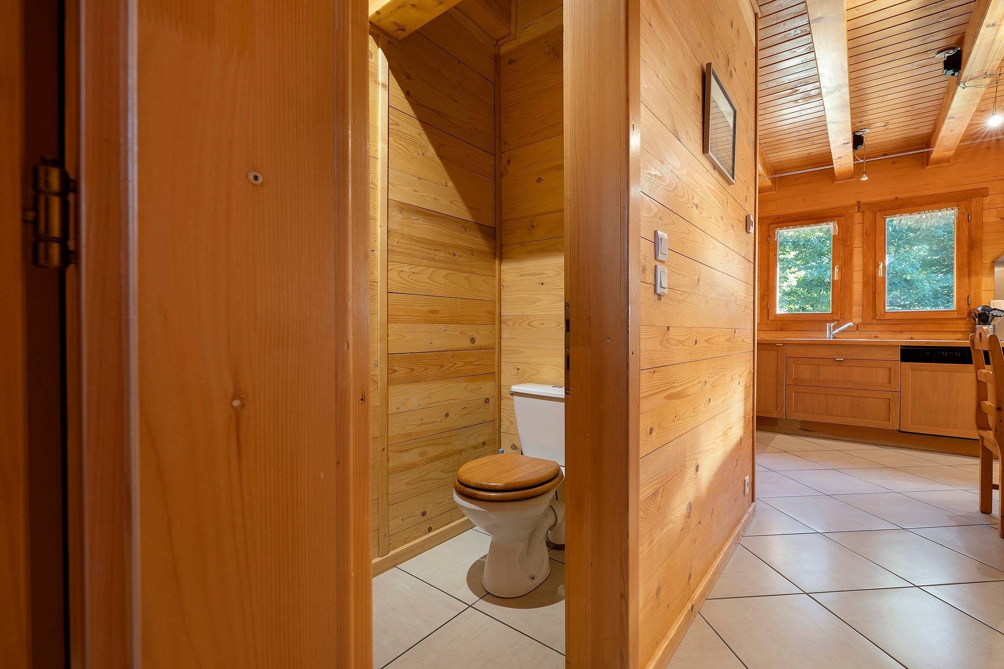 Un intérieur en bois comprenant des toilettes, un lavabo et des placards.