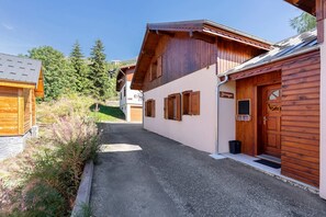 Ein schmaler Weg führt zu einem Holzhaus, an dem das Schild 'Jannige' hängt.