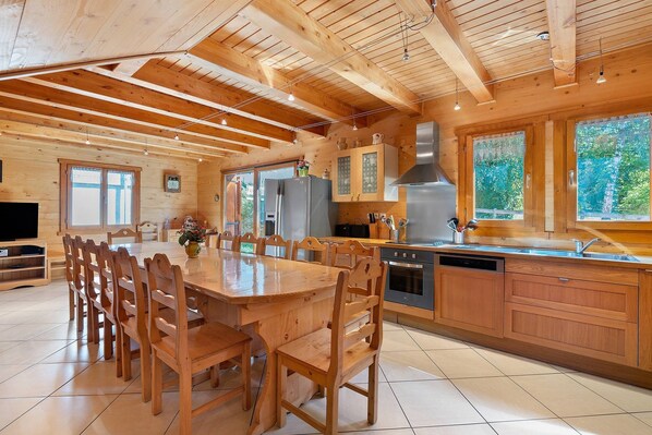 A spacious kitchen with wooden cabinets, a stainless steel range hood, and a large island with seating.