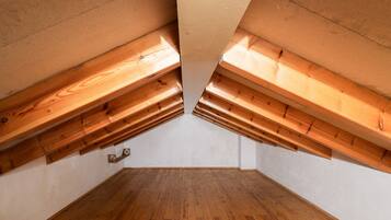 An attic room with wooden beams and a sloped ceiling.