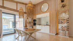 Eine moderne Küche mit weißen Schränken, einem Holztisch und einer Pendelleuchte.