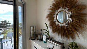 A kitchen with a large mirror, a coffee maker, a toaster, and a potted plant. - Ocean View XXL Terrace – Premium (Pornic)