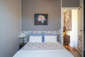 Une chambre à coucher avec un lit, une table de chevet, une lampe et un tableau au mur.