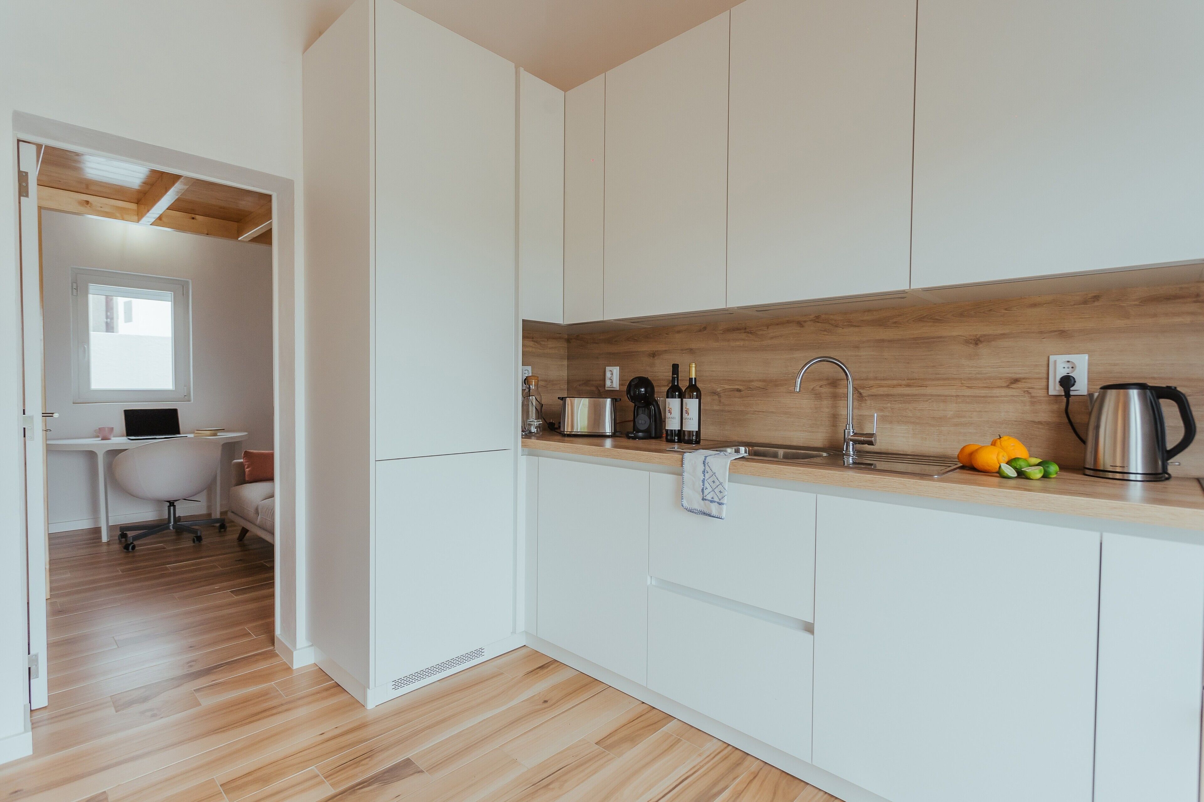 A modern kitchen with white cabinets, a wooden countertop, and a built-in sink.