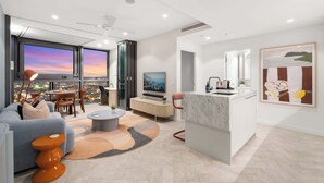 A modern living room with a sofa, coffee table, and a view of the cityscape through large windows. - Diamonds are Forever! 1Bed/1Bath/ Parking/VIEWS (Brisbane City)