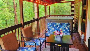 A covered outdoor seating area with wooden furniture and string lights. - Gatlinburg Resort Cabin - Hot Tub, Game Room, Sleeps 6  BOOK NOW FOR FALL COLORS (Gatlinburg)