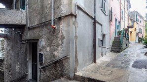 Una estrecha calle con una escalera de piedra que lleva a un edificio con una puerta y un letrero pequeño.