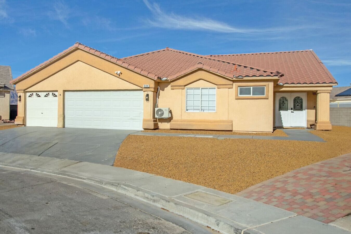 A two-story house with a garage, a small front porch, and a driveway.