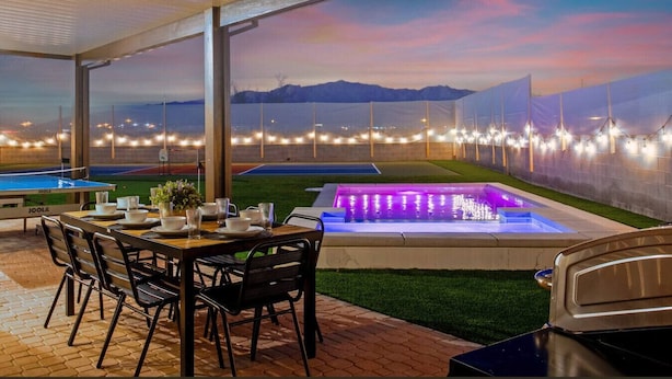 Ein Essbereich im Freien mit Pool, Whirlpool und Bergblick.