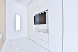 A modern room with a large window, white walls, and a marble floor.
