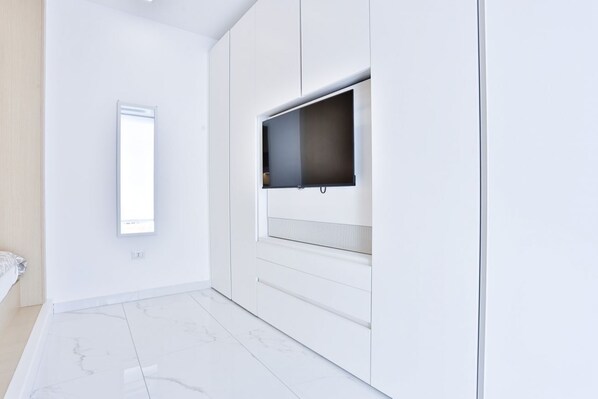 A modern room with a large window, white walls, and a marble floor.