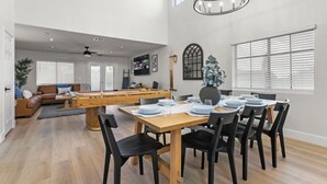 A spacious living area with a pool table, a dining table set for six, and a cozy seating area with a sofa and chairs. - Spacious 5 BD Home w/Theater, Billiard, and More! (North Las Vegas)
