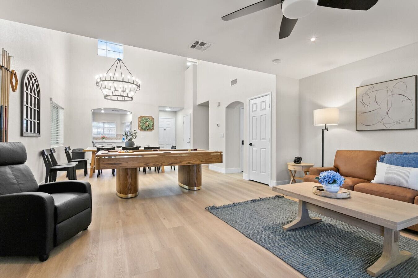A spacious living area with a pool table, a sofa, and a dining area.
