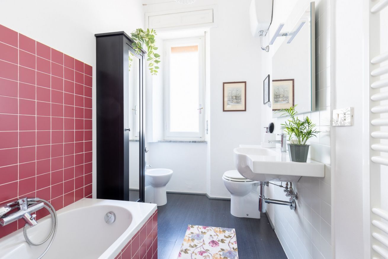 Ein modernes Badezimmer mit einer Badewanne, zwei Toiletten, einer Dusche und einem Waschbecken.